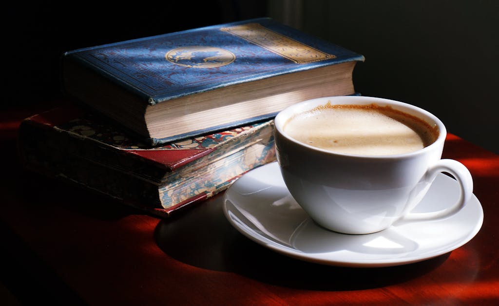 A cozy scene of a cappuccino with vintage books, perfect for relaxation.